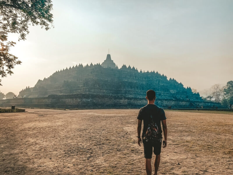 Visitor walking toward the upper terraces of Borobudur Temple