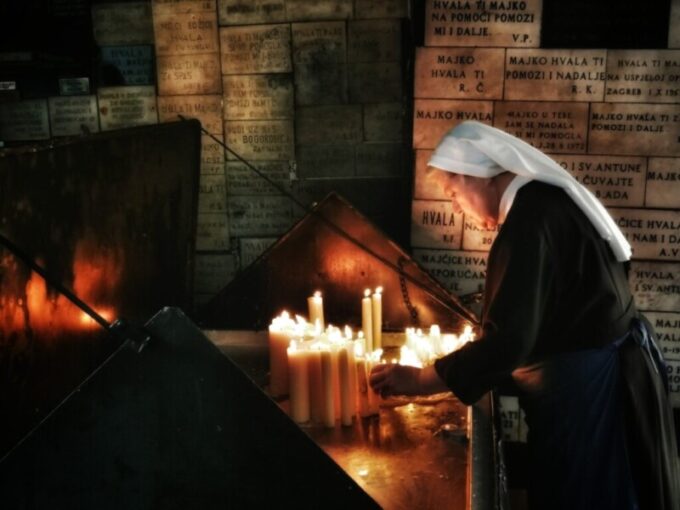 A nun lights up the candle at Stone Gate