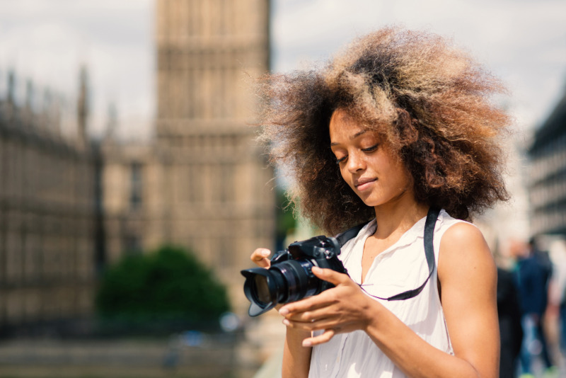 Woman with a camera taking photos on Westminster Bridge in London