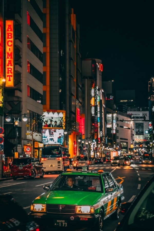 Green Vehicle in the road Surrounded by Buildings