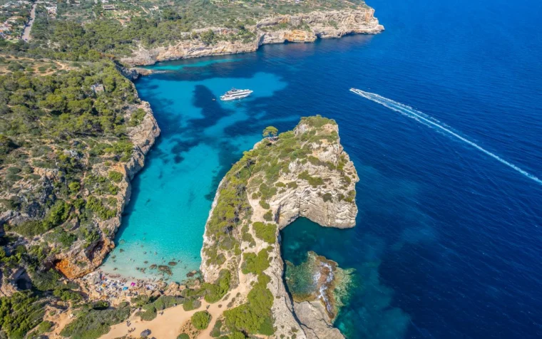 Aerial view of Calo des Moro, Mallorca - secluded slice of paradise with stunning cliffs, crystal-clear turquoise waters and lush greenery.