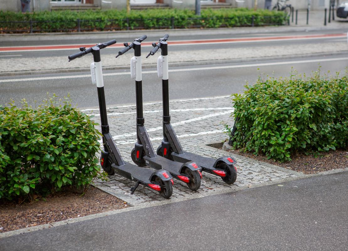 Electric scooters parked on a San Diego sidewalk, promoting eco-friendly urban commuting and reducing traffic.