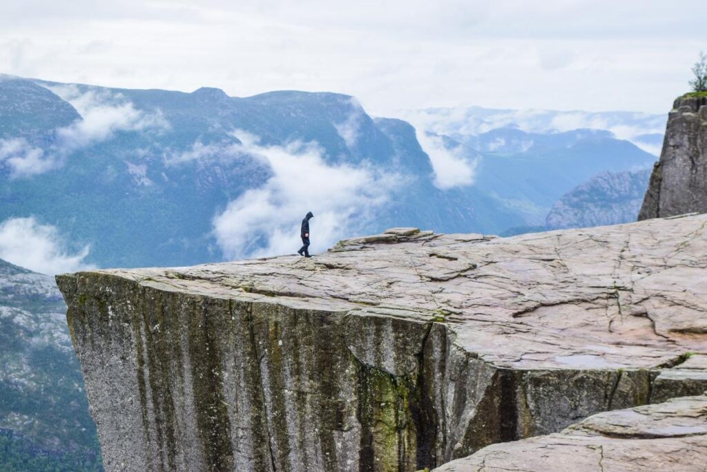 Hiker on Preikestolen Norway Misty Fjords View