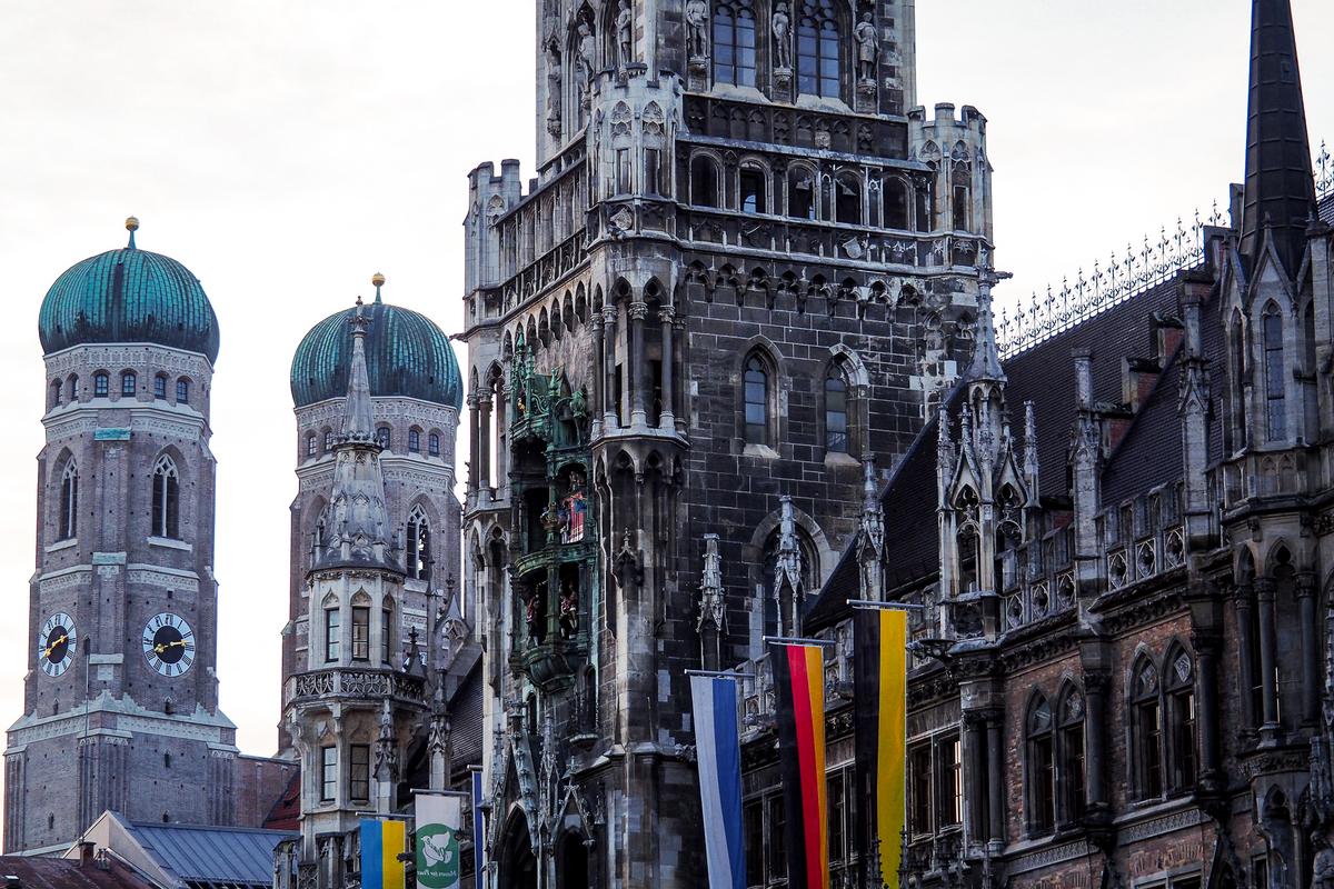 Gothic Architecture and Glockenspiel of Munich's New Town Hall with Frauenkirche Towers in the Background