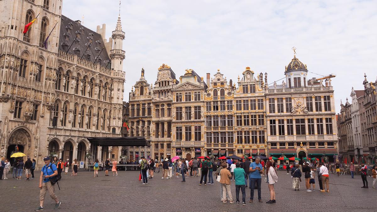 Busy Grand Place square with ornate guildhalls and lively crowd in Brussels