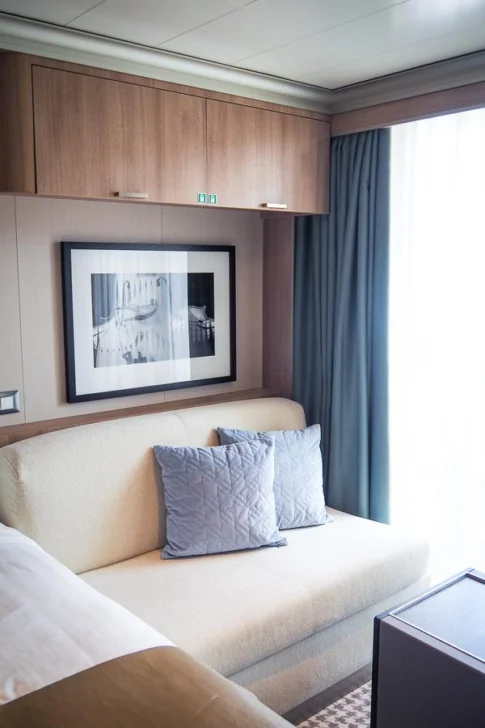 Elegant Holland America cruise ship cabin with modern decor and comfortable seating area