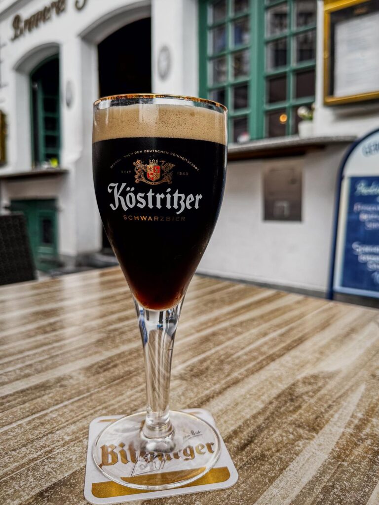 Köstritzer Schwarzbier in branded glassware at a traditional German pub, showcasing rich dark brew and beer glass details