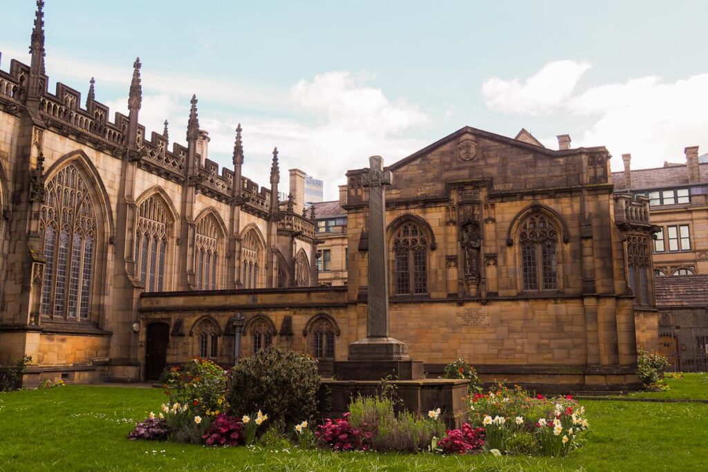 Manchester Cathedral in radiant sunlight, showcasing Gothic architecture and urban skyline