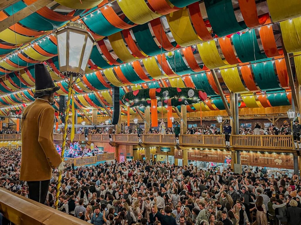 Crowd of festive-goers enjoying Munich's Oktoberfest inside the Schützenfestzelt beer tent.