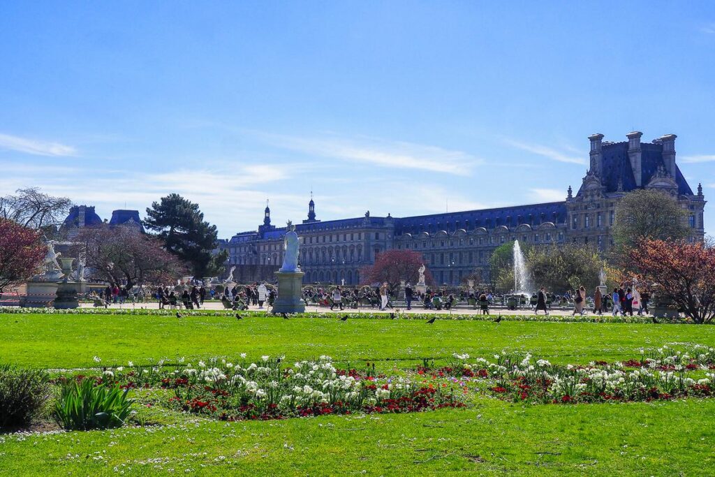 Springtime in Jardin des Tuileries with blooming tulips and historic Parisian buildings