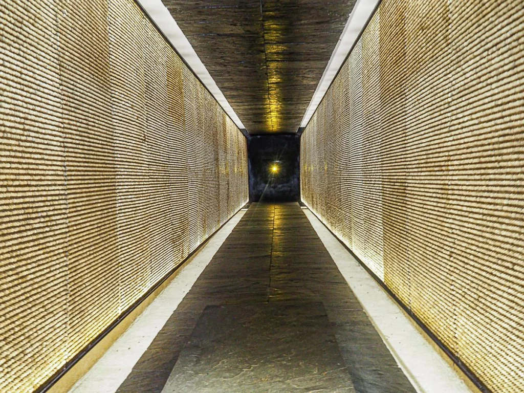 Solemn Corridor of the Deportation Martyrs Memorial in Paris, France, illuminated walls representing lives impacted by deportation