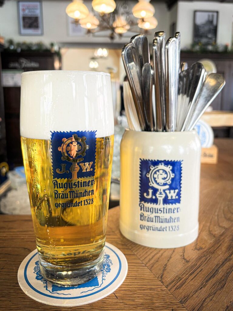 Traditional German beer poured in Munich's historic pub, featuring Augustiner beer and cozy ambiance.